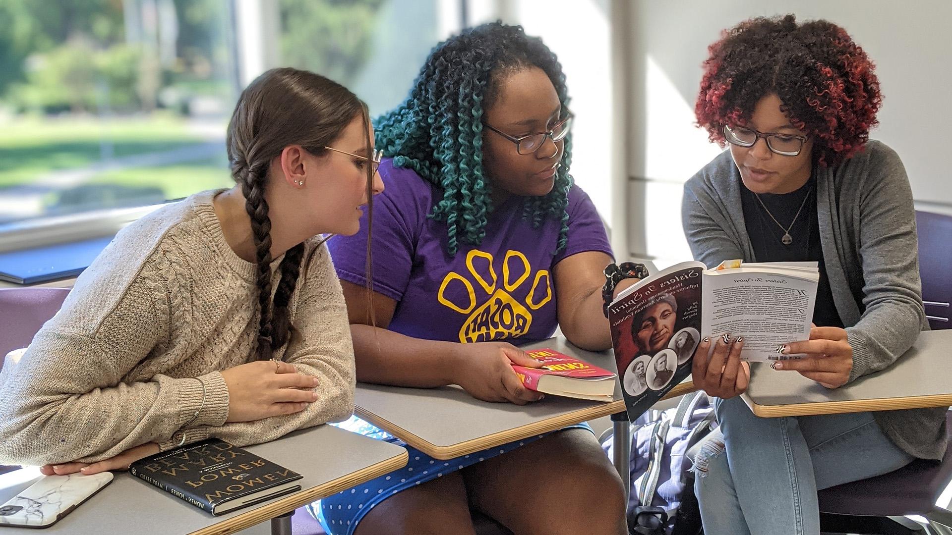 Gender and Women's Studies students group with book